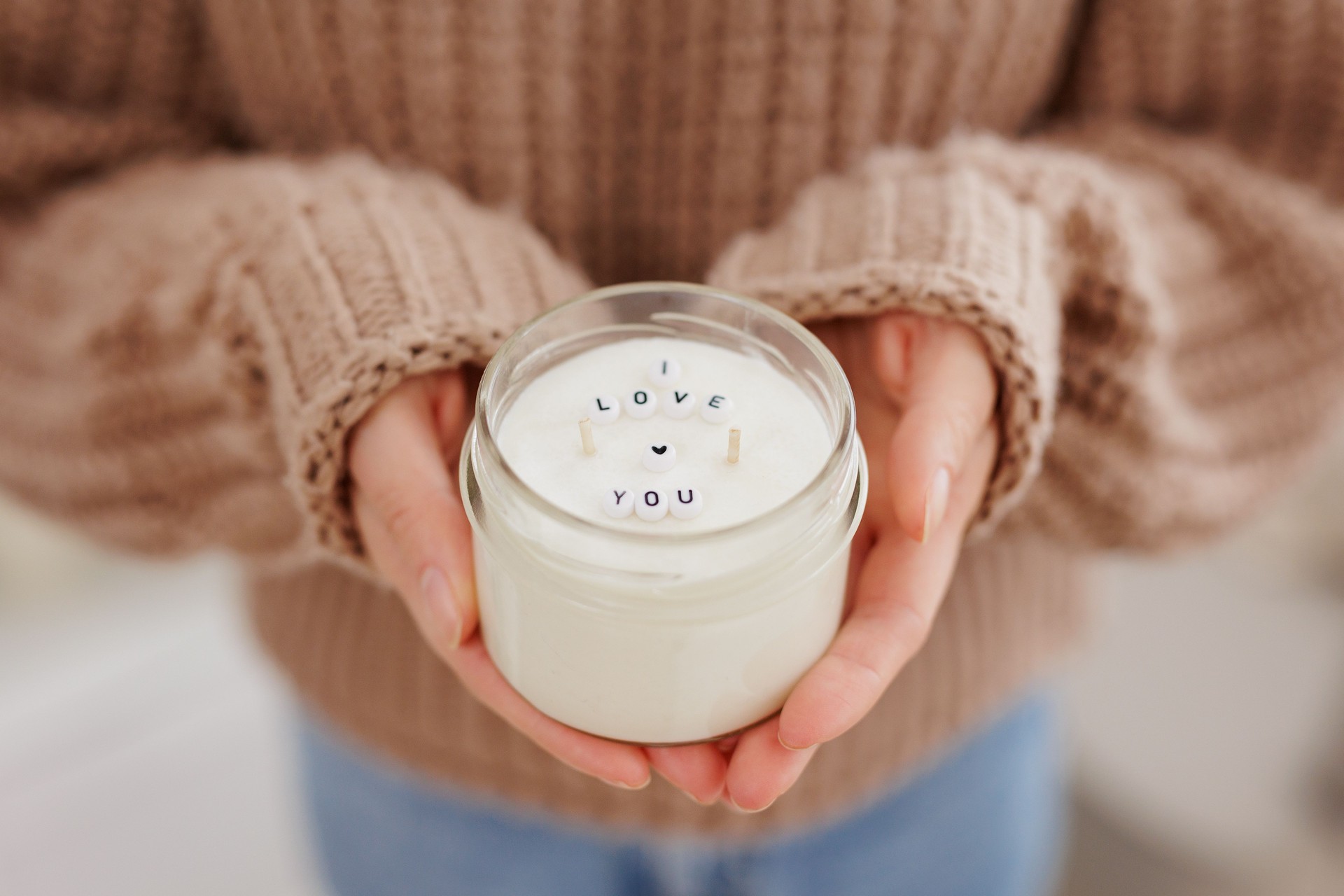 Woman holding candle in hands with text I love you